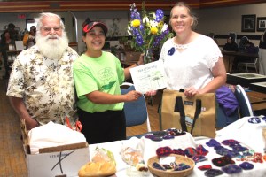 BoothOfTheWeekPeteKarrasMaybelleFillerMimiGoodwin Pete Karras, left, of Pete's Sourdough Bread, and Mimi Goodwin, right, of Just Arts, receive the Table of the Day Award from Maybelle Filler for the second Sitka Farmers Market of the season