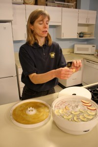 Julie Cascio of UAF Cooperative Extension Service's Health, Home and Family Development program in the Palmer/Mat-Su district demonstrates how to dry apples