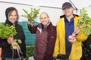 Sitka Local Foods Network board members Natalie Sattler, left, with parsnips, Lisa Sadleir-Hart, center, with turnips, and Doug Osborne, right, with turnips, show off some of the produce for sale at the final Sitka Farmers Market of 2009.