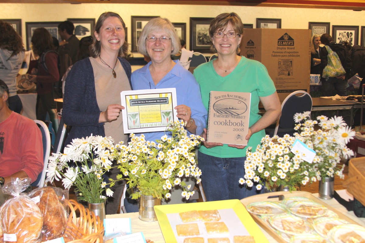Sitka Local Foods Network boardmember Johanna Willingham, left, presents Karen Christner, center, and Malinda Bonsen, right, of Malinda and Karen's Bakery with the Table of the Day award at the second Sitka Farmers Market of the summer on July 31 at Alaska Native Brotherhood Hall in Sitka.