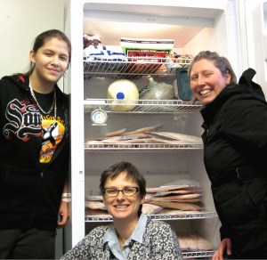 Pacific High School student Jessie Young, left, co-principal Sarah Ferrency, center, and lunch coordinator Johanna Willingham load rockfish into the freezer at Pacific High School. an alternative high school in Sitka, Alaska. (PHOTO COURTESY OF TRACY GAGNON / SITKA CONSERVATION SOCIETY)