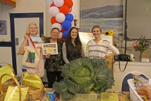 Sitka Farmers Market Co-Managers Debe Brincefield, left, and Ellexis Howey, right, present the Table Of The Day Award to Florence Welsh and her daughter Cory Welsh of Welsh Family Forget-Me-Not Gardens at the sixth and final Sitka Farmers Market of the 2014 summer on Saturday, Sept. 5, at the Alaska Native Brotherhood Founders Hall in Sitka. The Welsh family has one of the larger gardens in Sitka, raising a variety of veggies including cabbage, carrots, zuccini, potatoes, greens, and more. Florence received a gift bag with fresh greens, fresh carrots, fresh rhubarb, and a copy of the Alaska Farmers Market Cookbook. This concludes the seventh year of Sitka Farmers Markets, hosted by the Sitka Local Foods Network. While the Sitka Farmers Market is over for the summer, we will host a produce table at the 20th annual Running of the Boots, with registration at 10 a.m., costume judging at 10:30 a.m. and race at 11 a.m. on Saturday, Sept. 27, near St. Michael of the Archangel Russian Orthodox Cathedral on Lincoln Street. For more information about the Sitka Farmers Markets and Sitka Local Foods Network, go to http://www.sitkalocalfoodsnetwork.org/, or check out our Facebook page at https://www.facebook.com/SitkaLocalFoodsNetwork. (PHOTO COURTESY OF SITKA LOCAL FOODS NETWORK)