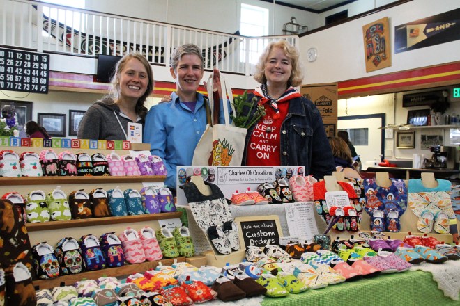 Sitka Local Foods Network Board Secretary Alli Gabbert, left, and Sitka Farmers Market Manager Debe Brincefield, right, present the Table Of The Day Award to Jennifer "Springer" Black of Charlee Oh Creations at the first Sitka Farmers Market of the 2015 summer on Saturday, July 4, at the Alaska Native Brotherhood Founders Hall in Sitka. Springer is a new vendor at the Sitka Farmers Market and she sold handmade soft-soled shoes for babies and toddlers, some with matching bibs. Springer received a gift bag with fresh greens, fresh rhubarb, fresh mint, and some handmade earrings donated by Taylor Ihde. This is the eighth year of Sitka Farmers Markets, hosted by the Sitka Local Foods Network. The next market is from 10 a.m. to 1 p.m. on Saturday, July 18, at the Alaska Native Brotherhood Founders Hall, 235 Katlian St. Bring your canner pressure gauge to this market to have it checked. For more information about the Sitka Farmers Markets and Sitka Local Foods Network, go to http://www.sitkalocalfoodsnetwork.org/ or check out our Facebook page at https://www.facebook.com/SitkaLocalFoodsNetwork. (PHOTO COURTESY OF SITKA LOCAL FOODS NETWORK)