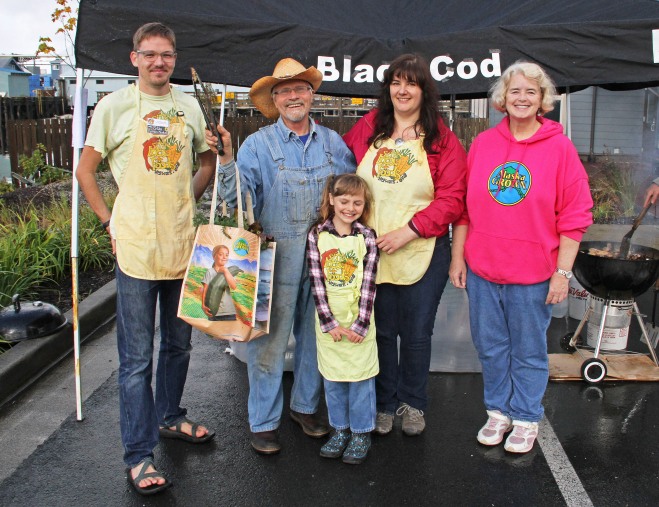 Sitka Farmers Market Assistant Manager Francis Wegman-Lawless, left, and Sitka Farmers Market Manager Debe Brincefield, right, present the Table Of The Day Award to Kerry MacLane, second from left, and his Sitka's Blackcod Collars helpers Autumn Mayo, center, and Ilona Mayo, second from right, at the sixth and final Sitka Farmers Market of the 2015 summer on Saturday, Sept. 12, at the Alaska Native Brotherhood Founders Hall in Sitka. MacLane is a regular participant at the Sitka Farmers Market with his grilled blackcod collars/tips served over rice with beach asparagus, kale, and other greens for a garnish. This was the eighth year of Sitka Farmers Markets, hosted by the Sitka Local Foods Network. While the Sitka Farmers Markets are over for 2015, the Sitka Local Foods Network will host a produce booth at the Running of the Boots on Saturday, Sept. 26, near St. Michael's Russian Orthodox Church. The Running of the Boots is a costumed fun run fundraiser for the Sitka Local Foods Network, where people run a short race in their XtraTufs (aka Sitka Sneakers). Registration opens at 10 a.m., with costume judging about 10:30 a.m. and the race start at 11 a.m. For more information about the Sitka Farmers Markets, Running of the Boots, and Sitka Local Foods Network, go to http://www.sitkalocalfoodsnetwork.org/, check out our Facebook page at https://www.facebook.com/SitkaLocalFoodsNetwork, or follow us on Twitter at https://www.twitter.com/SitkaLocalFoods. (PHOTO COURTESY OF SITKA LOCAL FOODS NETWORK)